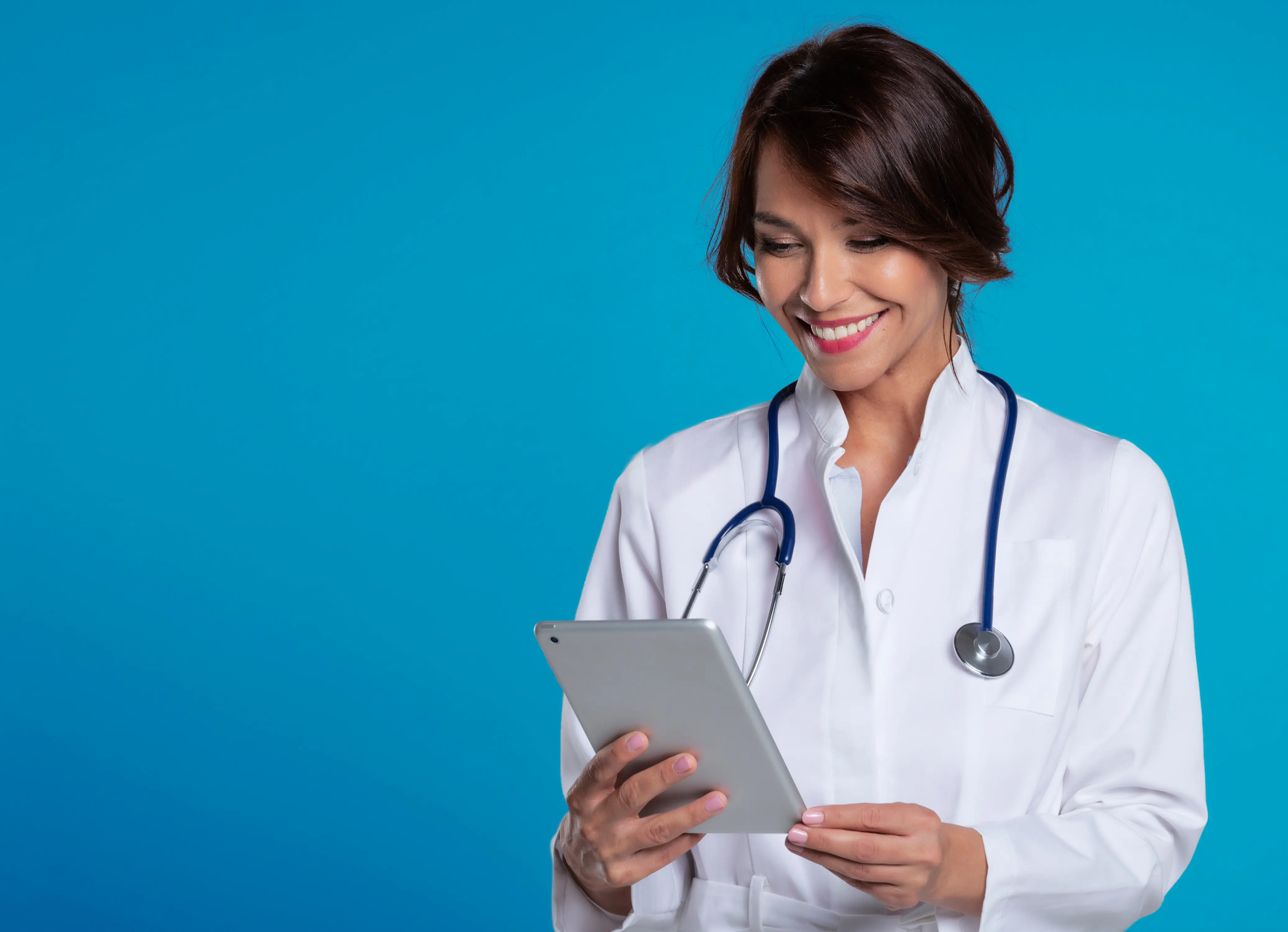 Female healthcare provider looking down with stethescope around neck against blue background.